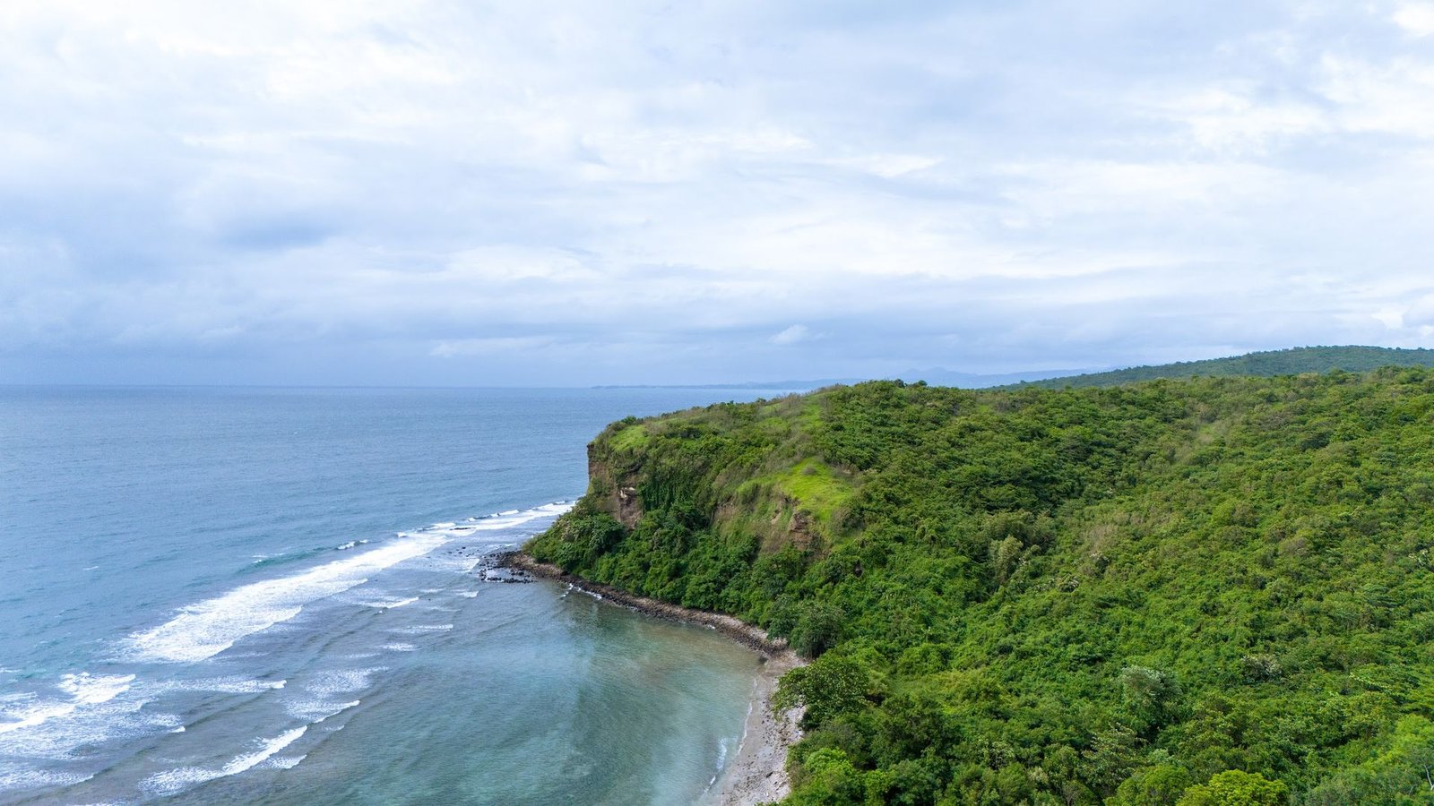 Waves meeting the green headland